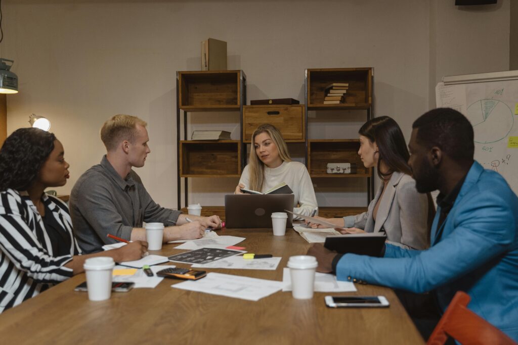Business owners and accountant reviewing year-end financials around a meeting table